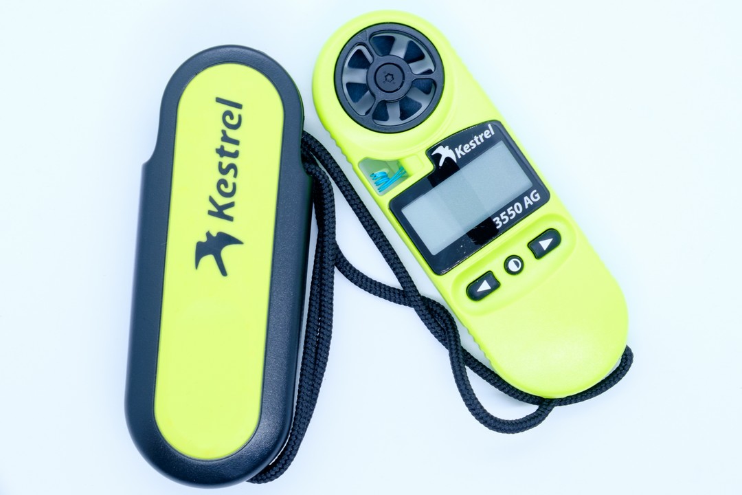 The Kestrel Weather Meter for Spray Applications displayed with its hard case and lanyard.